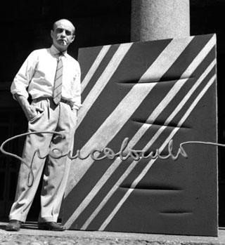 Lucio Fontana nel suo studio con un taglio. Milano, 1960